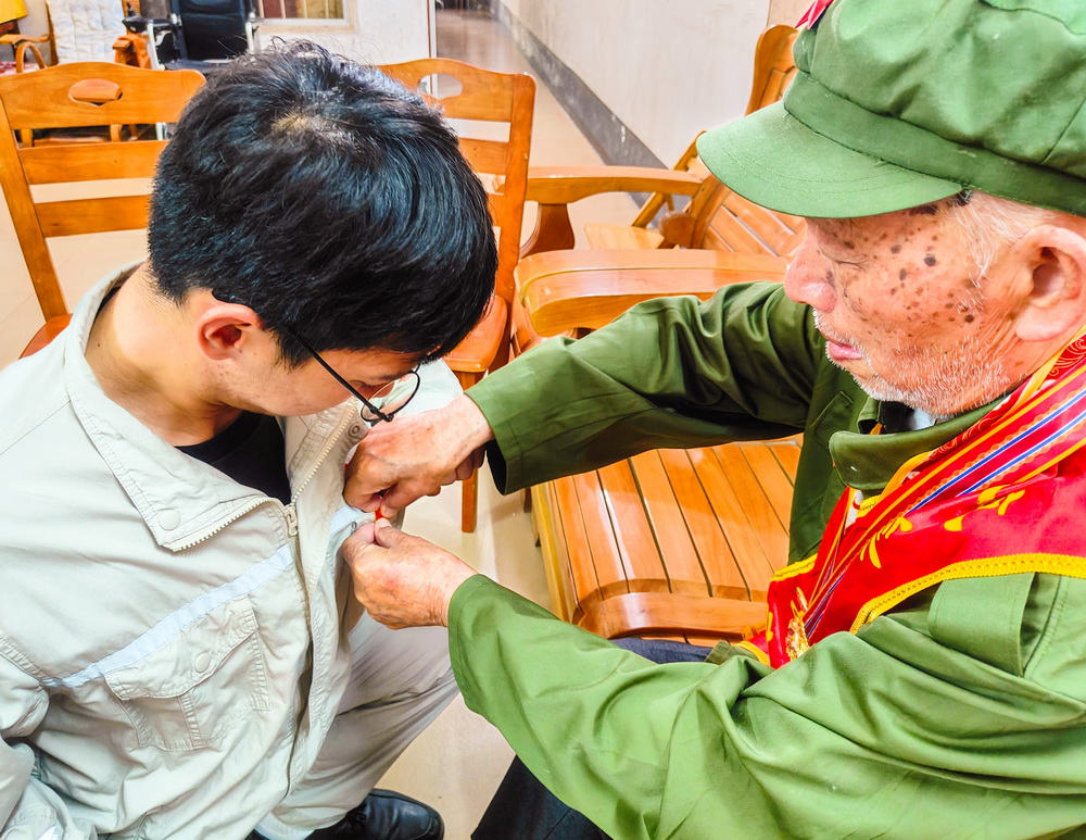 2、韋仕隆給新入黨的青年黨員佩戴黨章--李陽攝.jpg